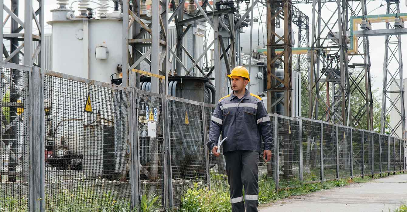 Trabajador de mantenimiento caminando en una subestación eléctrica